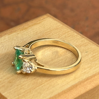 14KT Yellow Gold Oval Emerald + Trillion Diamond Ring